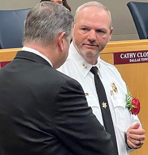 New Gaston County Sheriff Chad Hawkins receives badge from Alan Cloninger that was passed to Cloninger when he became Sheriff by Leroy Russell.